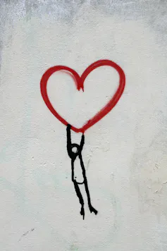 A figure holding up a heart.