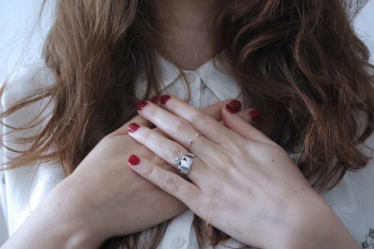 Woman with her hands on her chest.