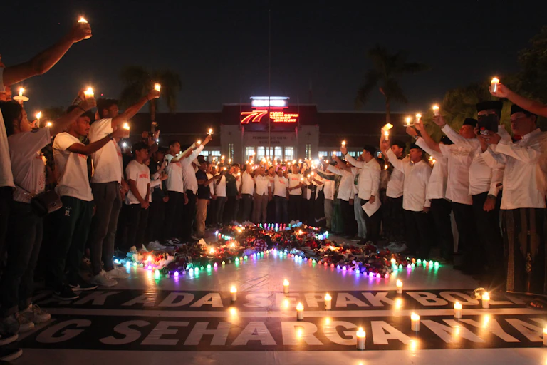Warga membawa lilin saat doa bersama di Balai Kota Surabaya, Jawa Timur, Selasa (4/10/2022) malam. Doa bersama itu untuk para korban tragedi kerusuhan di Stadion Kanjuruhan, Malang.
