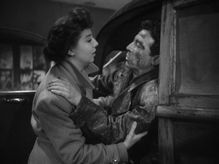 Un hombre herido se abraza a una mujer.