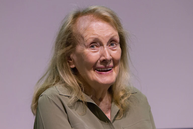 A woman in green top smiles.