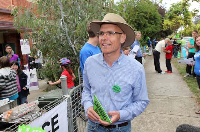 Clive Hamilton, a man in a shirt and belted jeans, with an Akubra, wearing a Greens badge