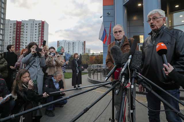 Two board members of Russian human rights organisation 'Memorial' speaking to the media