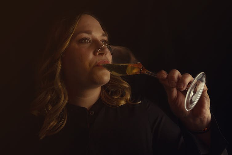 A woman drinks champagne.