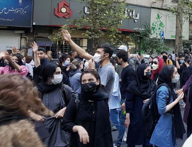 Young Iranians protesting in Tehran over the death of a young woman at the hands of the morality police, October 2022.