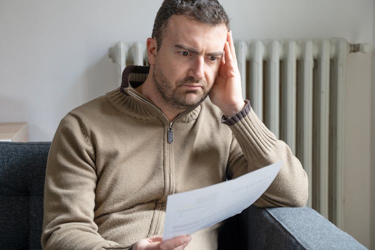 Confused man looks at energy bill