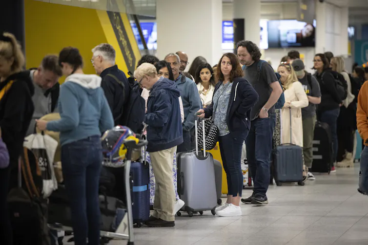Travellers queue to check in for their flights at Gatwick Airport in London, Britain, 31 May 2022.