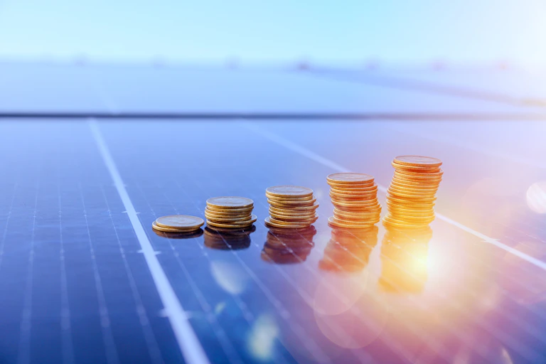 Montones de monedas sobre panel solar.