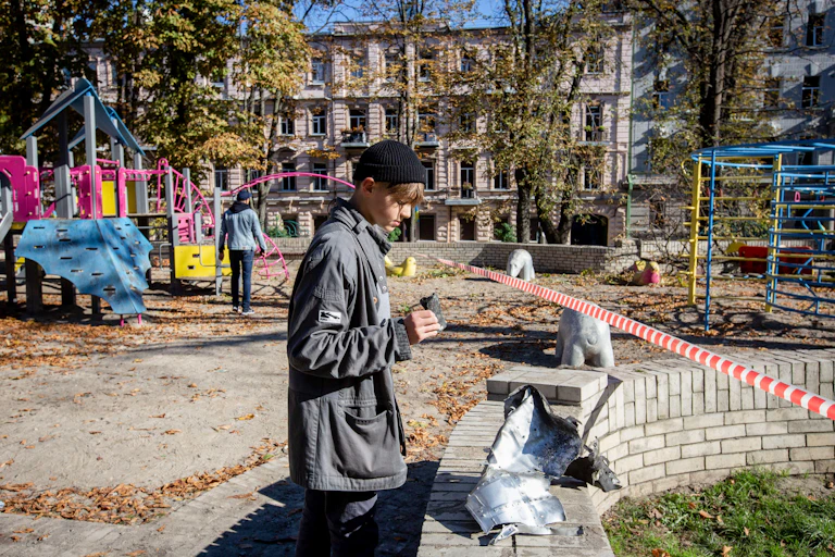 Kyiv, Ukraine. 10th Oct, 2022. A boy looks at a rocket fragment after a Russian missile attack in central Kyiv.