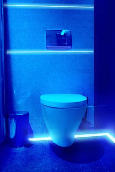 Public restroom lit with uv blue light