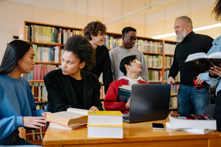 Students seen in discussion in a library.