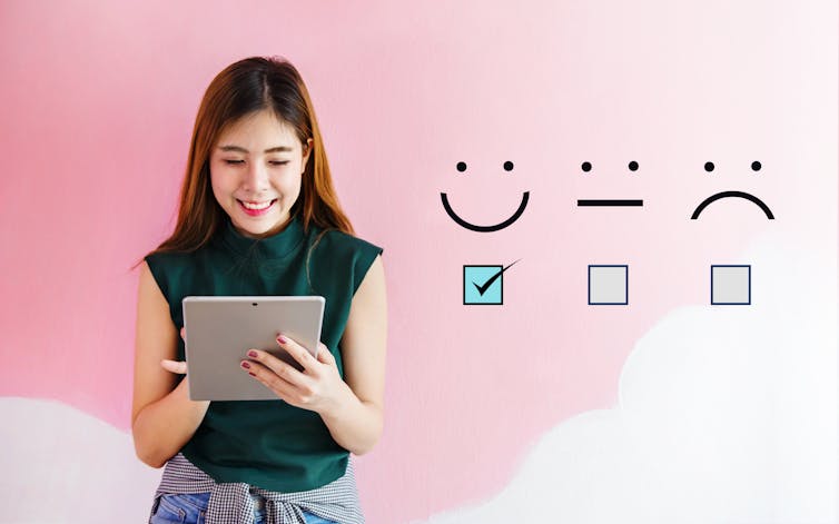 A person filling out a digital survey next to a row of response options.