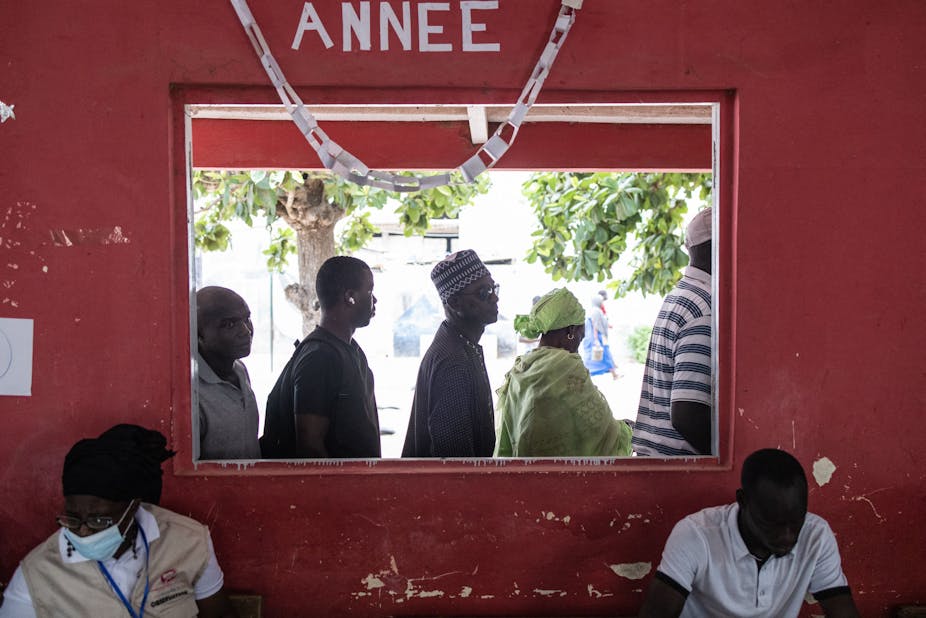 People wait in line outside their voting station in the popular neighbourhood of Ngor in Dakar on July 31, 2022.