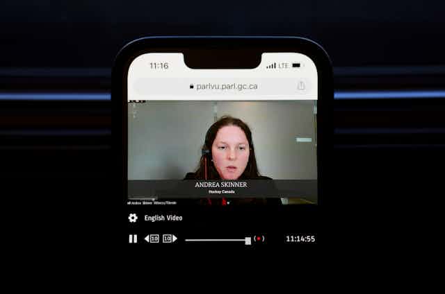 a photo of a smartphone screen showing a woman speaking with the title ANDREA SKINNER HOCKEY CANADA