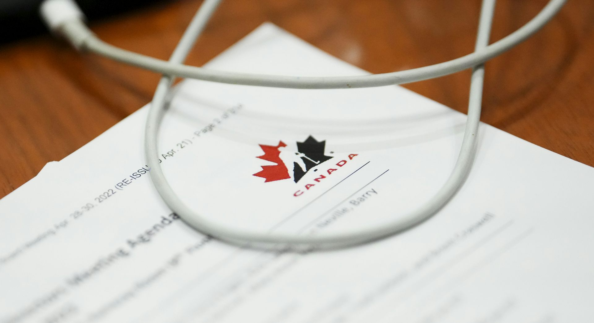 a document on a desk showing the Hockey Canada logo, a white sillhouetted hockey player against a red and navy blue Canadian maple leaf