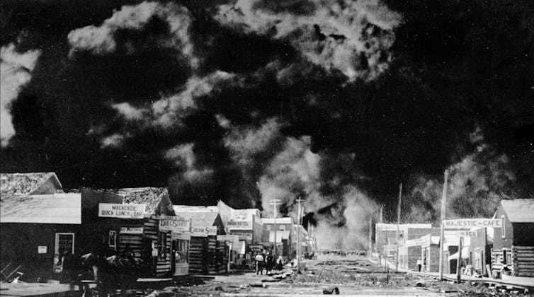 A black and white image of a burning city.