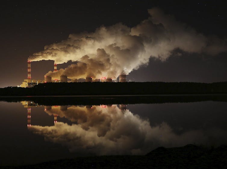 Plumes of smoke rise from a power plant