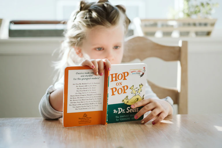Young girl reading the book 'Hop on Pop'.