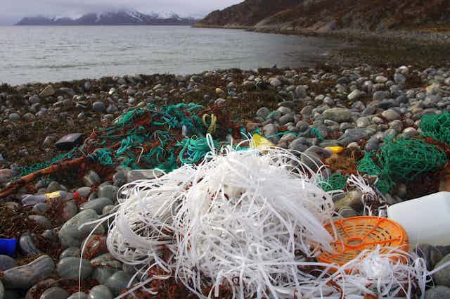 White and green plastic fishing gear on rocks by the sea