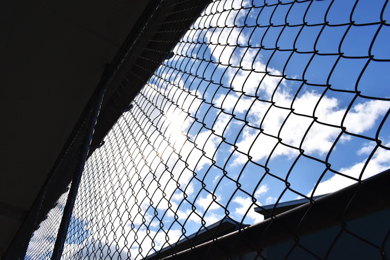 Prison wires in the foreground in front of the sky
