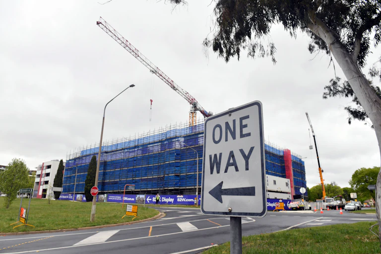 One way sign in front of apartment buildings under construction