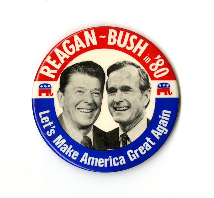 A campaign button emblazoned with the faces of two men is topped with the words 'Reagan-Bush in '80'