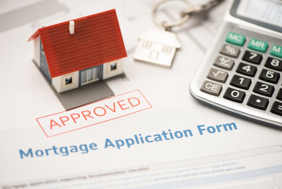 Model home, mortgage application form stamped "Approved", calculator and keys.