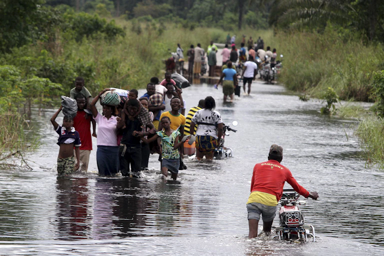 Nigerians move along a flooded road in Okpe, Isoko north local goverment council Niger delta