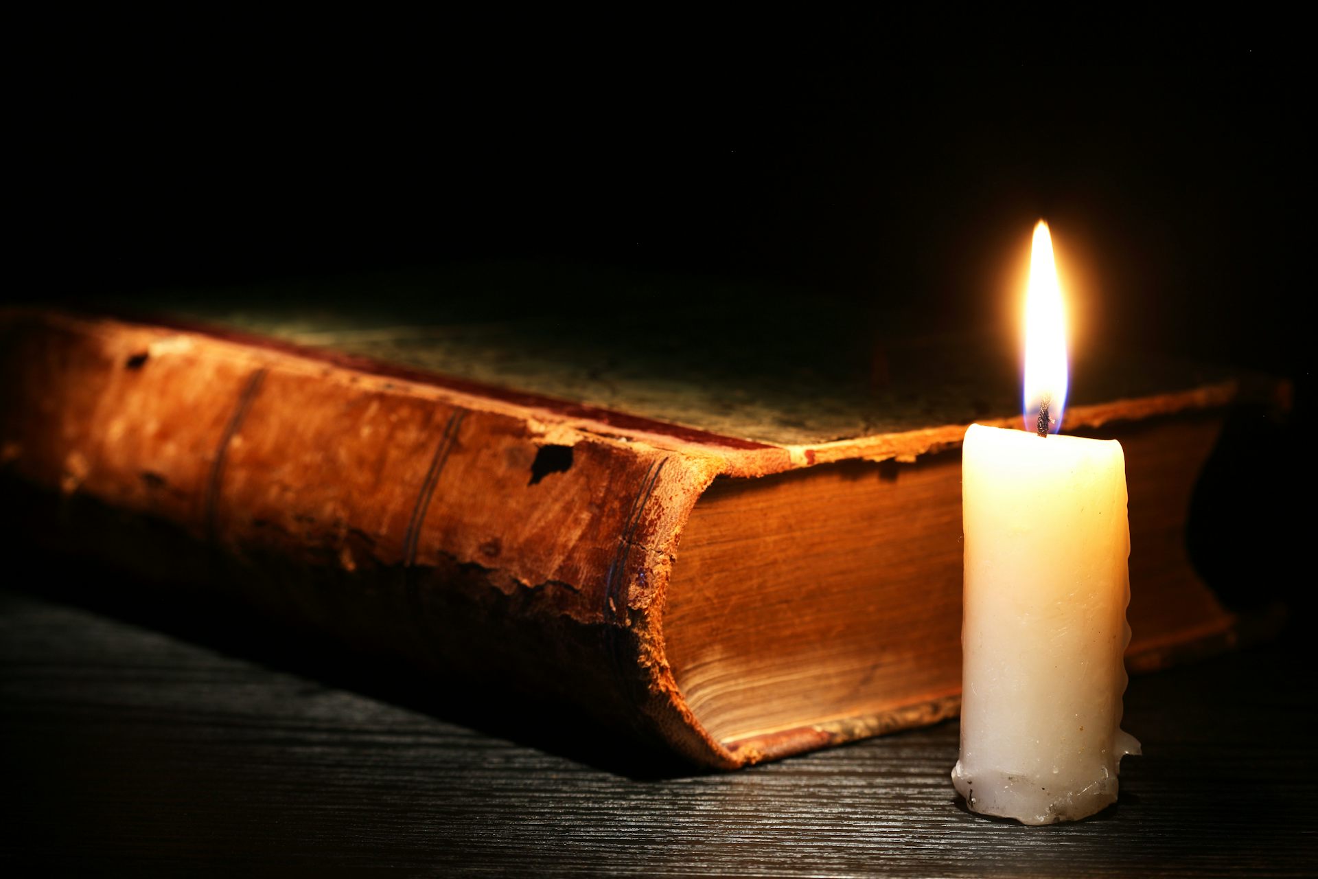 A candle next to a book.