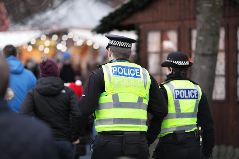 View from behind of two police officers in high vis vests at an event