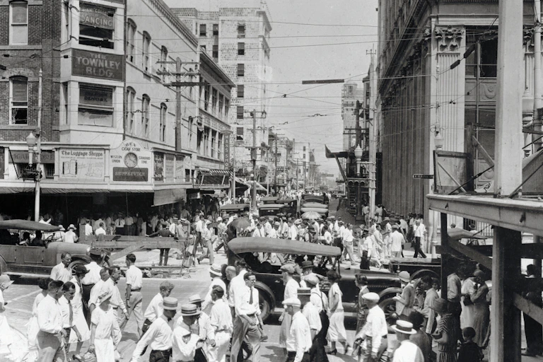 A black and white photo taken in the early 20th century in a city.
