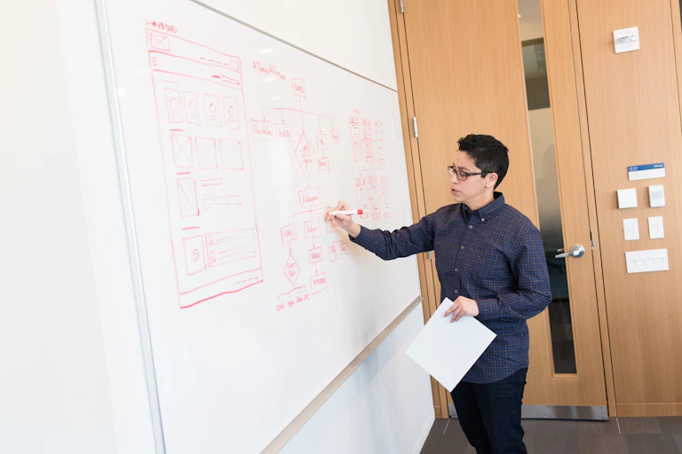 Teacher drawing a diagram on whiteboard.