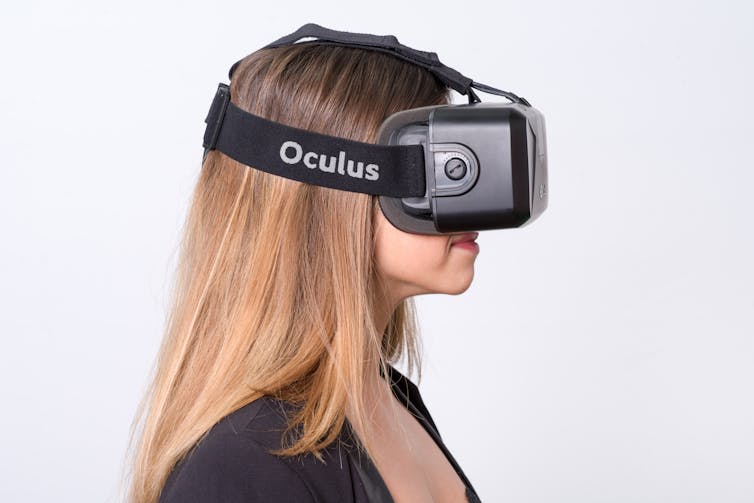 A woman wearing a headset that says OCULUS