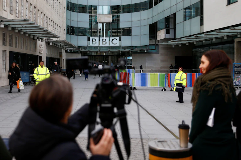 Members of the media wait as the BBC logo is seen outside Broadcasting House, as the corporation announced it will cut around 450 jobs from its news division, in London, Britain January 29, 2020.