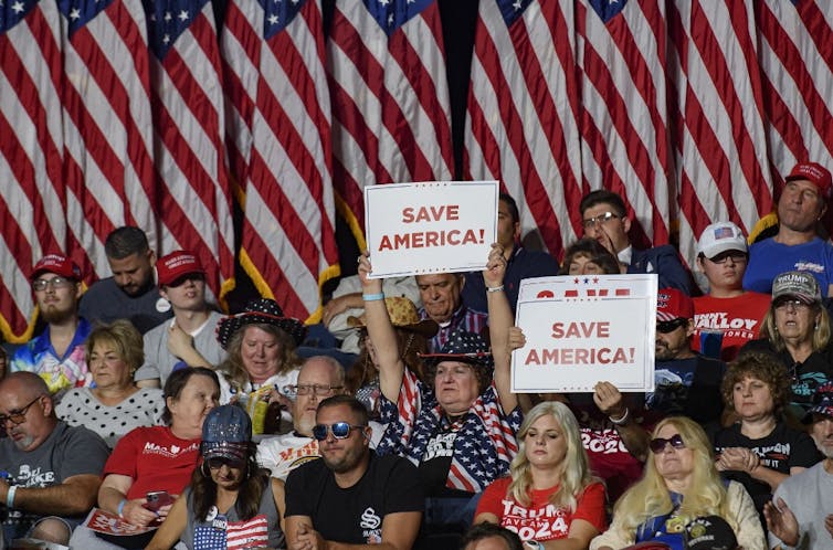 Personnes brandissant des pancartes « Save America »
