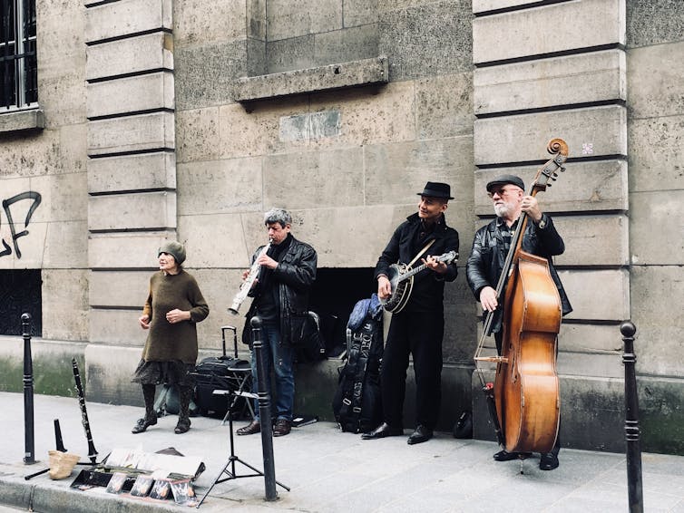 A woman dances and three men play jazz instruments.