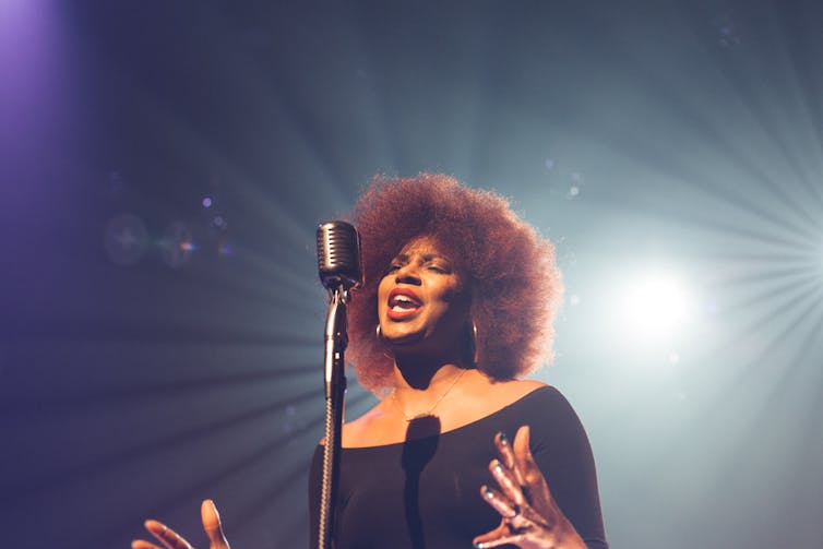 A Black woman sings.