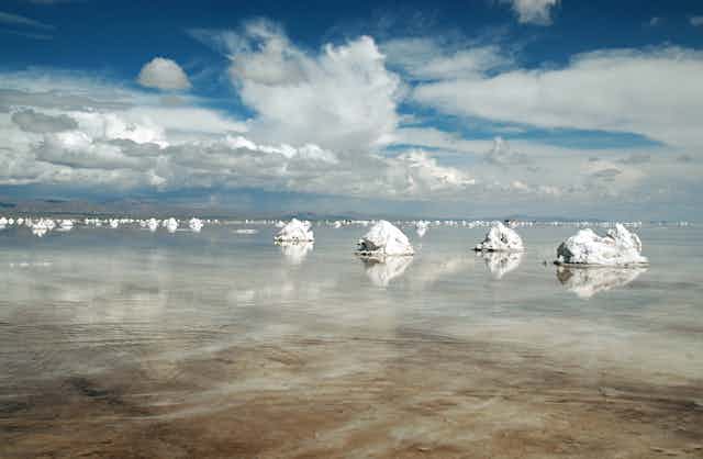 Los montones de sal se reflejan en el agua.