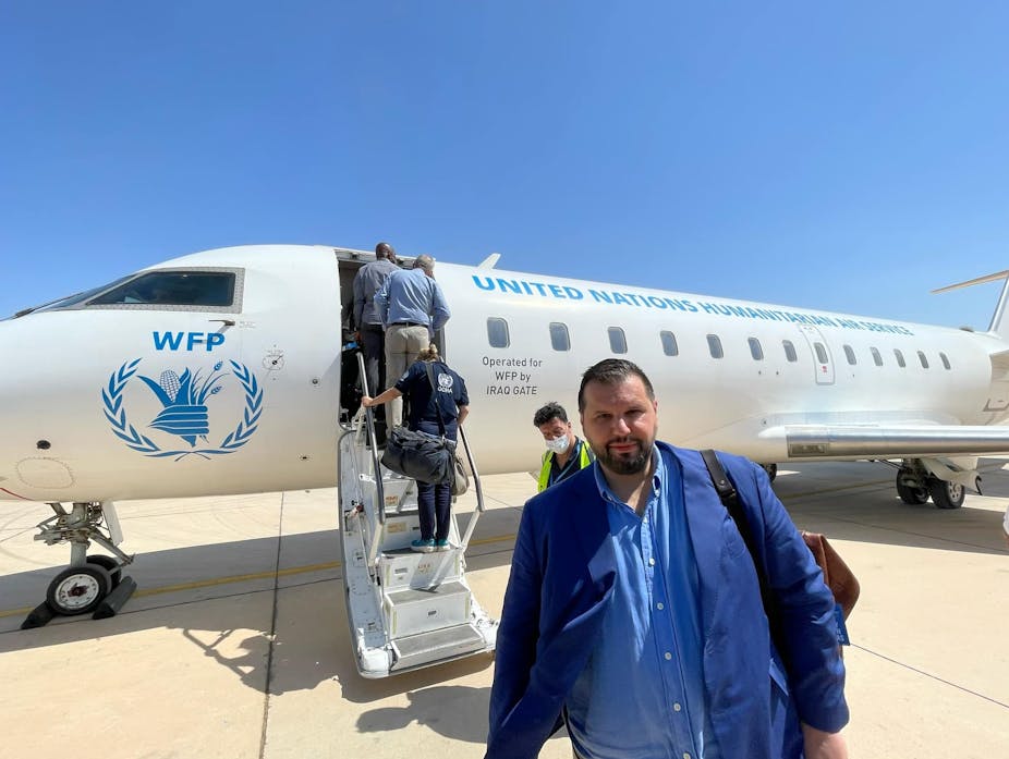Dan Stoenescu devant un avion du Programme alimentaire mondial