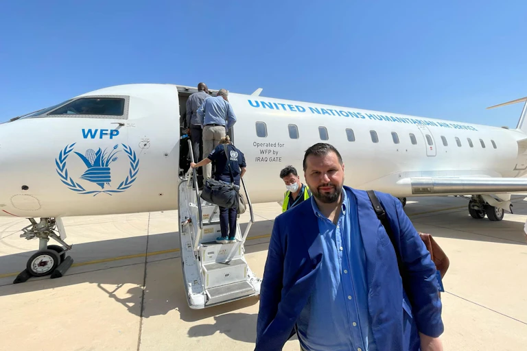 Dan Stoenescu devant un avion du Programme alimentaire mondial
