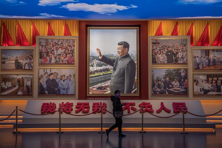 A visitors walks in front of pictures showing Chinese President Xi Jinping, at the Museum of the Communist Party of China, in Beijing, China, 23 November 2021.