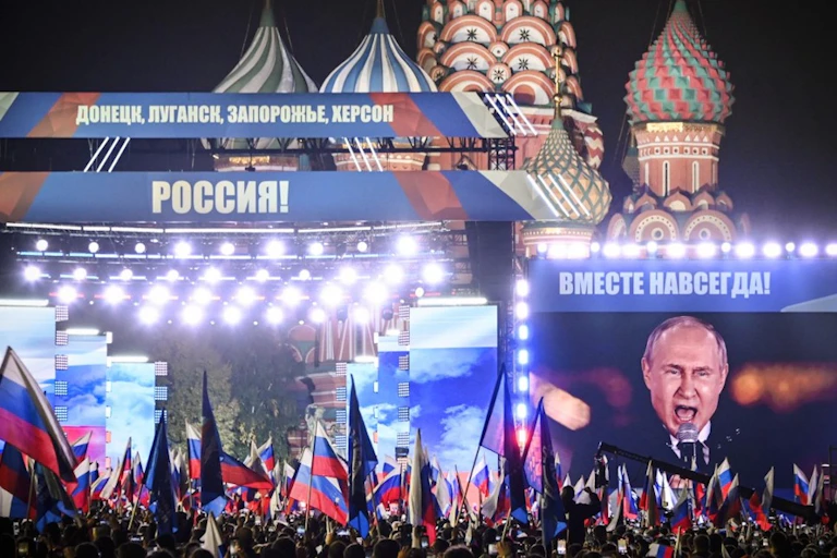 Nuée de drapeaux russes sur la place Rouge à Moscou, de nuit. Banderoles « Donetsk, Lougansk, Zaporijia : Russie » et « Ensemble pour toujours ».