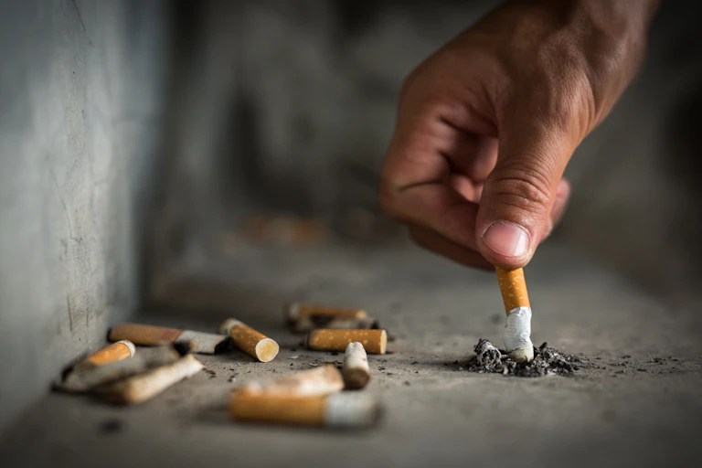 A hand seen stubbing out a cigarette
