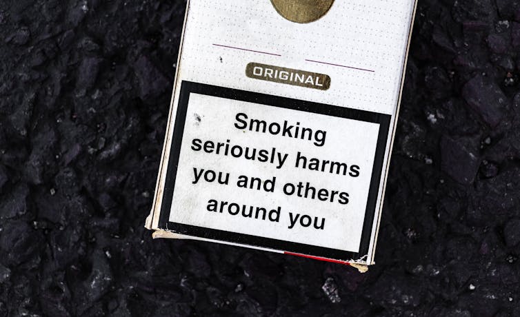 A plain cigarette pack with a warning about the harms of smoking