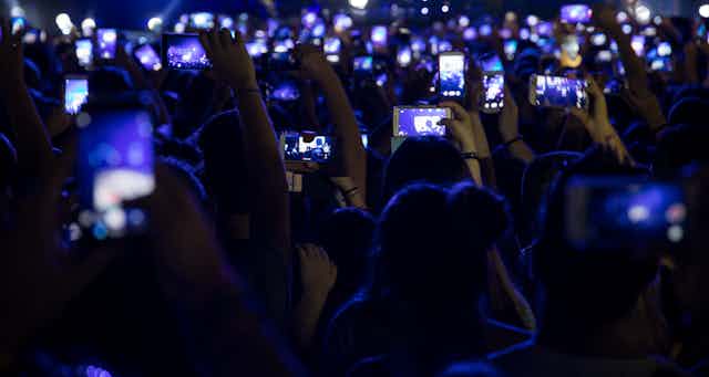 Concert crowd holding up phones.