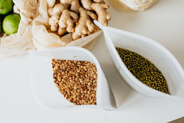 Two bags of legumes sit on a kitchen bench.