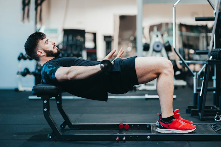 Un homme fait des mouvements de hanches une salle de sport