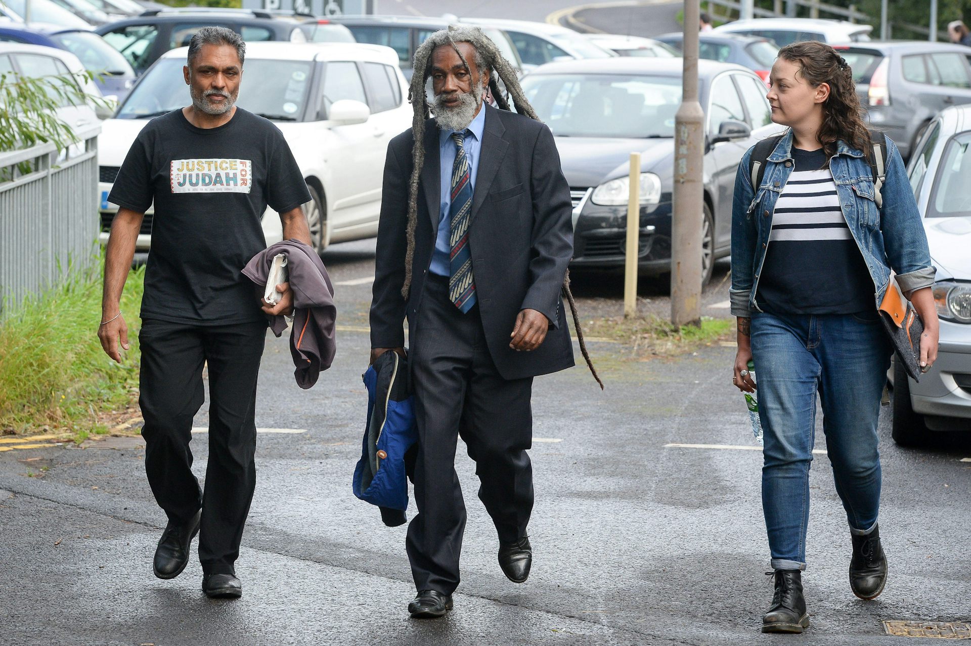 A man in a suit, a man in a t-shirt and a woman in jeans.