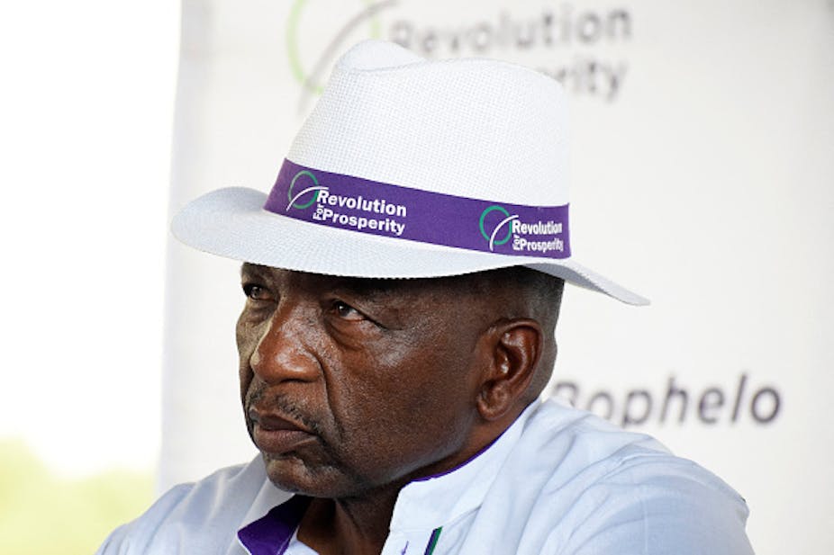 A man in a pensive mood is wearing a panama hat bearing the name of Lesotho's new 'Revolution for Prosperity' party.