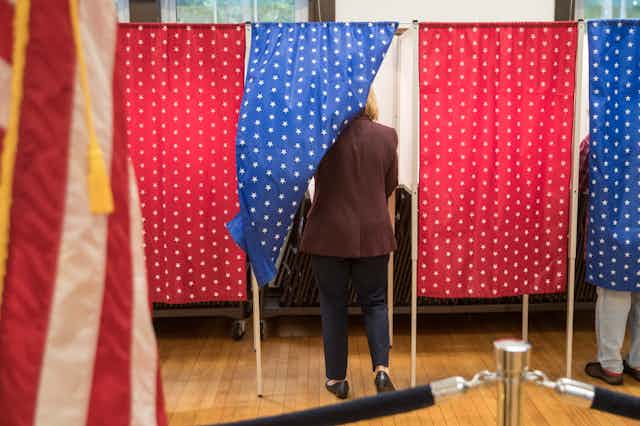 A view from behind a person in a polling place.
